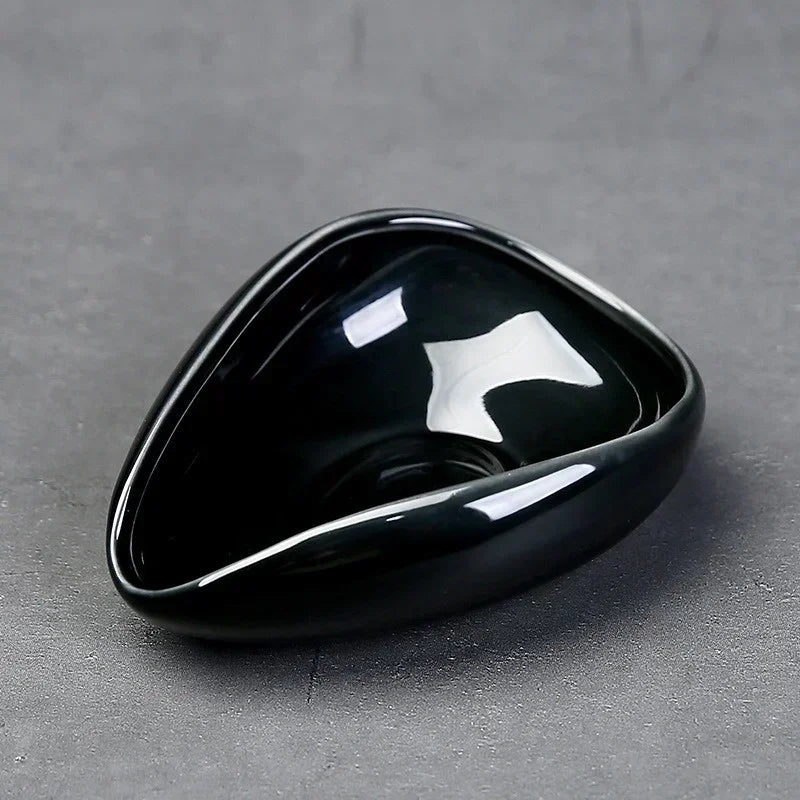 Black ceramic triangle bowl for coffee accessories on gray surface