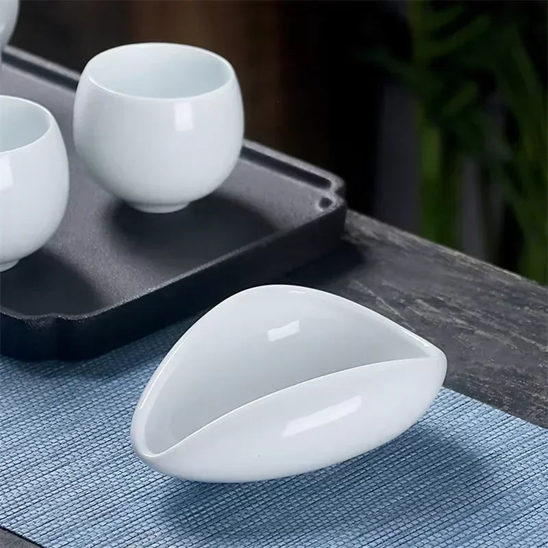 Modern white ceramic cup set with unique leaf-shaped bowl on a blue placemat, home barista accessory