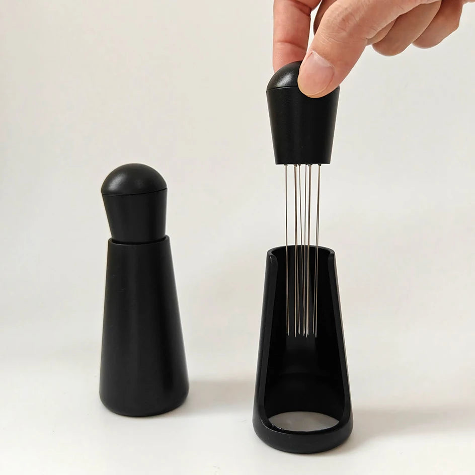 Espresso distribution tool with fine needles and black holder for coffee puck preparation
