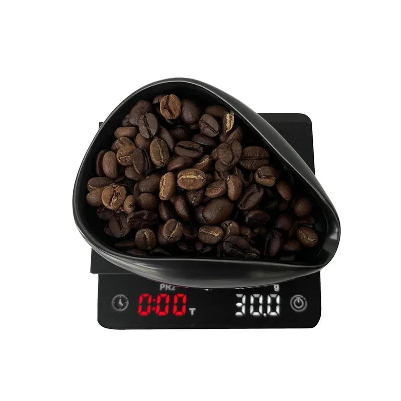 Coffee beans in a black dosing tray on a digital coffee scale with red LED display