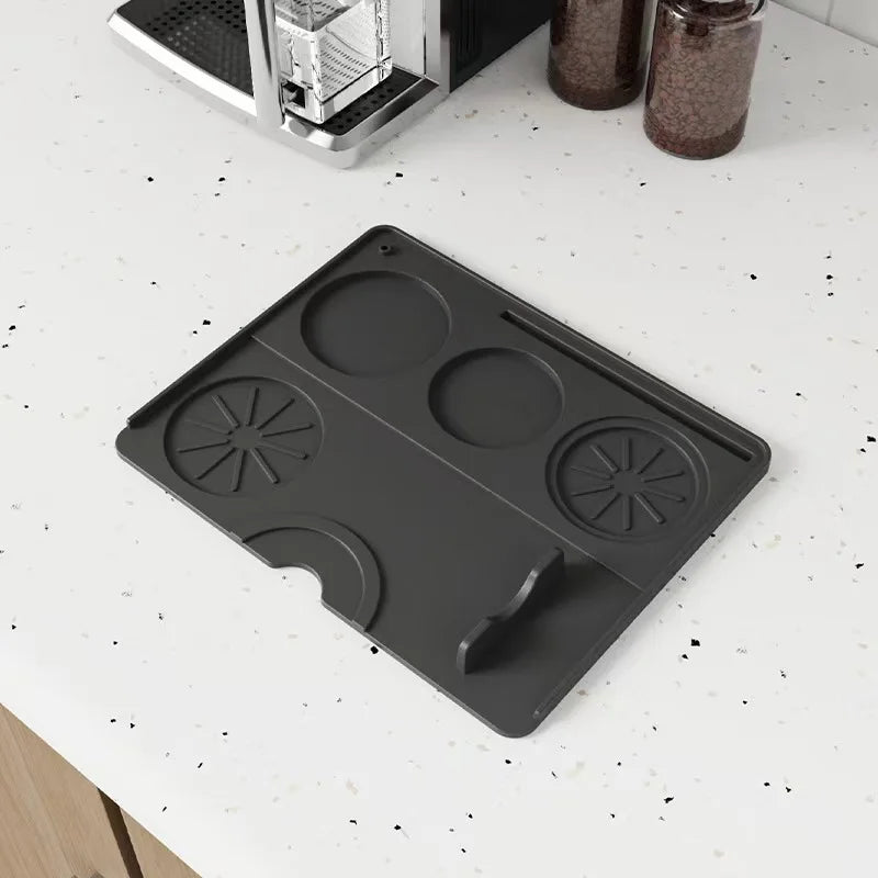Espresso tamping mat for coffee accessories on kitchen countertop near coffee machine.