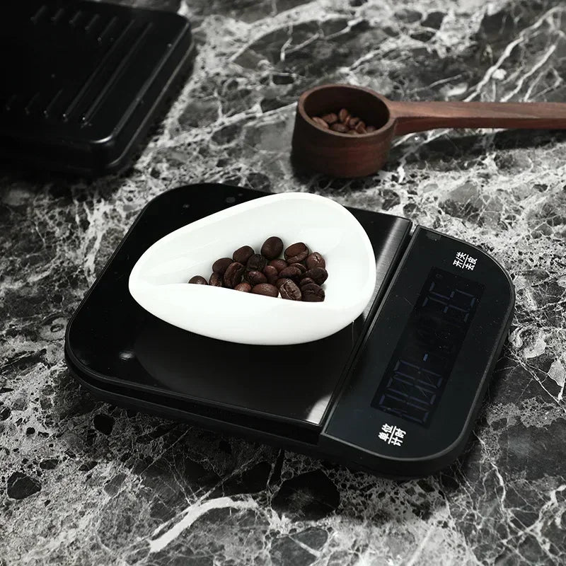 Digital coffee scale weighing coffee beans in white bowl on marble countertop